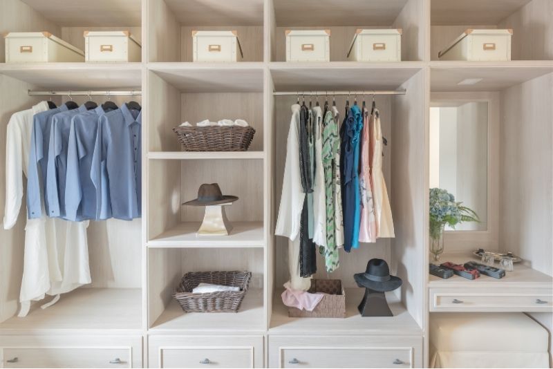 custom wardrobe closet filled with clothes, hat and boxes