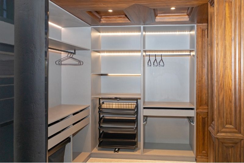 empty wardrobe with lights and few clothes hanger