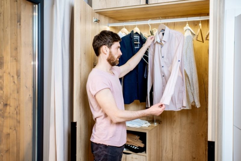 man standing infront of the wardrobe checking his longsleeve