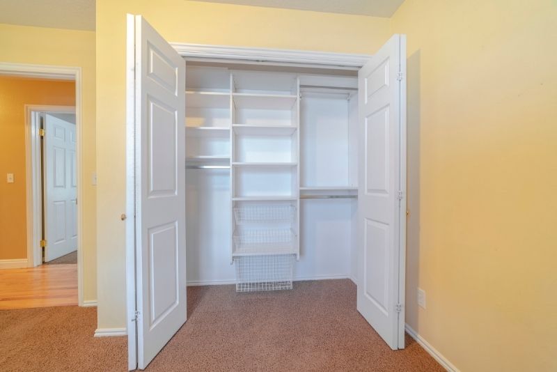 White built in wardrobe in laminate timber. It has two open doors